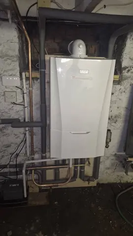 New Ideal boiler on a stone basement wall with lagged pipework